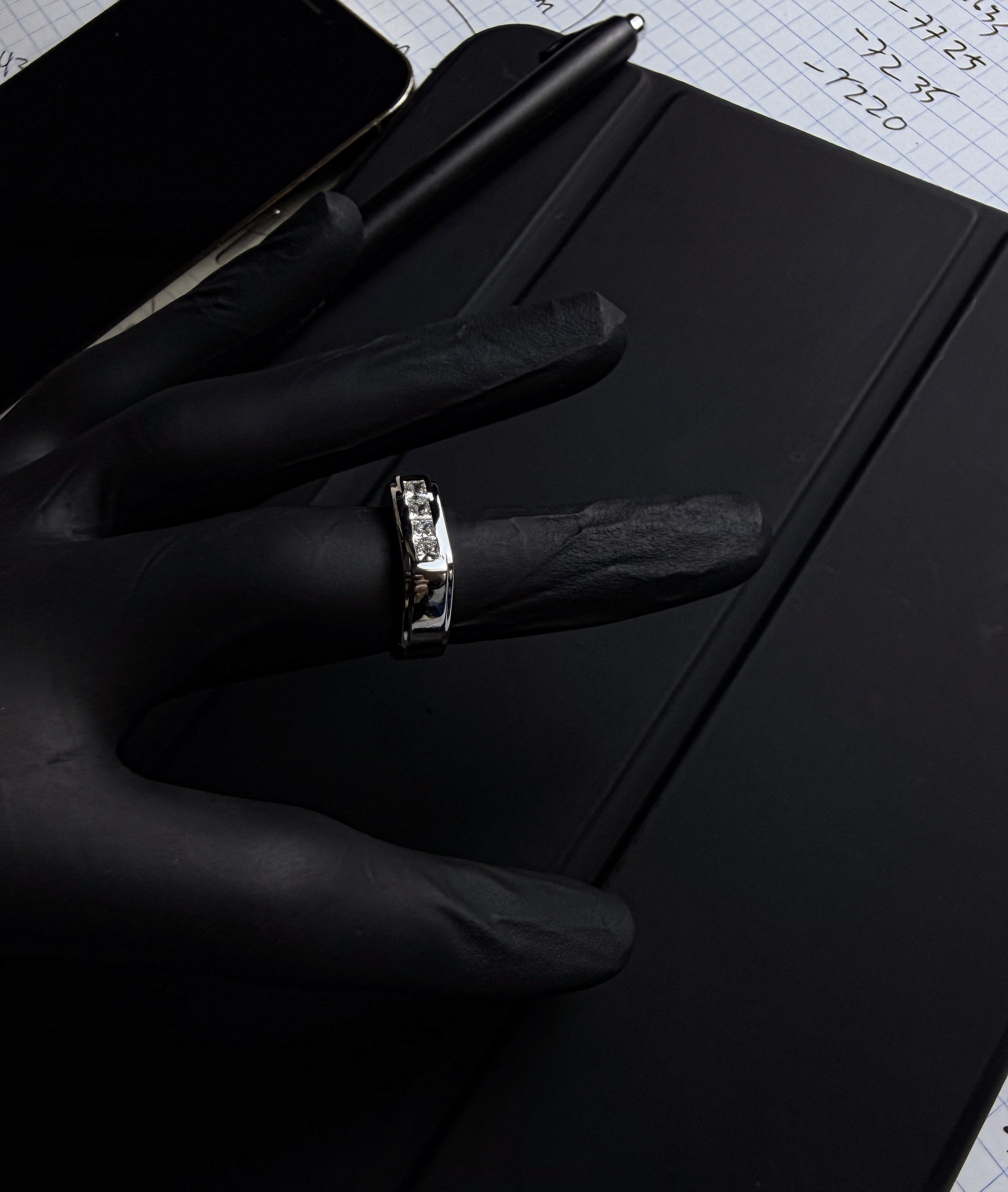 Diamond channel ring detail on gloved hand